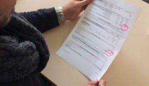 La signora mostra la cartella che le è stata recapitata (Websource)