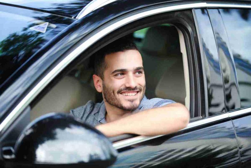 Guidatore al volante della sua auto noleggiata a lungo termine