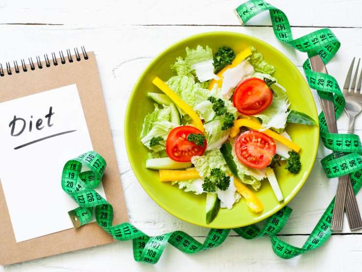 piatto con insalata e blocco notes con su scritto diet